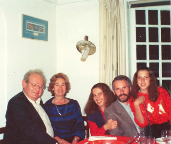 Családi vacsora az asztalnál Családi vacsora az asztalnál, poharakkal és tányérokkal, háttérben ablak és falilámpa.